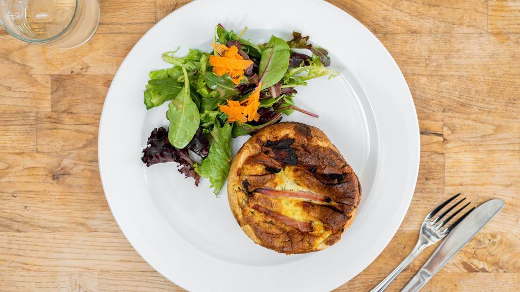 Quiche · Home-made seasonal quiche in a puff pastry tart served with mixed organic baby greens.