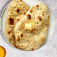 The Grinning Garlic Naan · Freshly baked bread in a clay oven garnished with garlic and butter