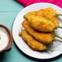 Jalapeño Poppers · Spicy jalapeños, stuffed with cheese, breaded and fried to golden perfection.