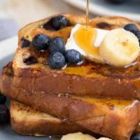 Banana Blueberry French Toast · French toast with banana and blueberry served with syrup and butter.