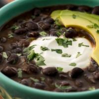Black Bean Soup · A flavorful combination of black beans, fresh onions, Mexican sausage, tomatoes, and com.
