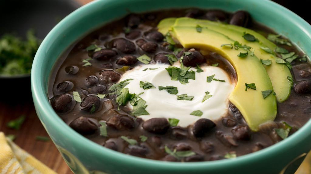 Black Bean Soup · A flavorful combination of black beans, fresh onions, Mexican sausage, tomatoes, and com.