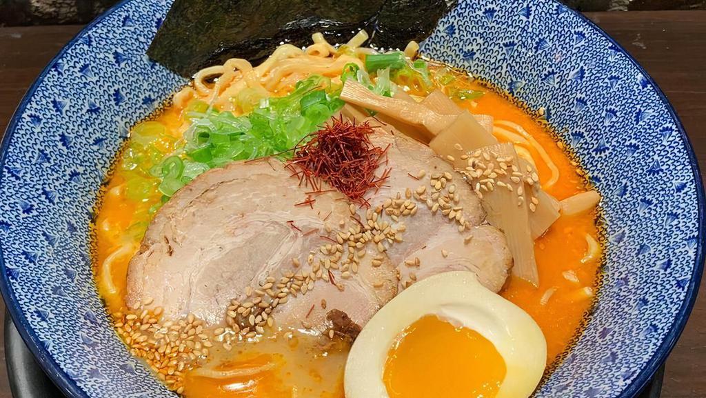 Spicy Miso Ramen · Wheat noodle in spicy dashi (bonito and seaweed) broth flavored with miso, chicken and, pork oil. Topped with chashu pork, menma (bamboo shoot), ajitsuke tamago(marinated egg), nori (dried seaweed), green onion, sesame seeds and red string pepper.