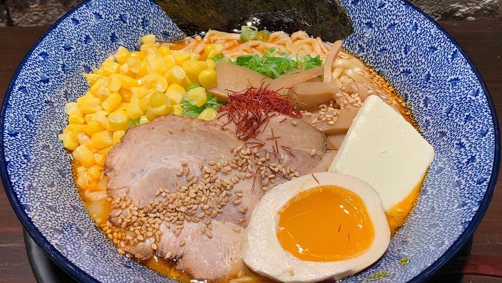 Spicy Miso Butter Corn · Wheat noodle in spicy dashi broth(seaweed and bonito) flavored with miso, chicken and, pork oil. Topped with chashu pork, menma (bamboo shoot), ajitsuke tamago( marinated egg), butter, corn, nori( dried seaweed), green onion, sesame seeds and red string pepper.