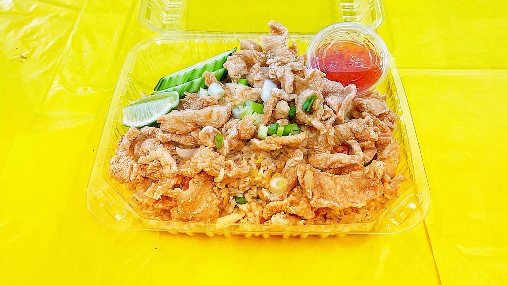 Crispy  Chicken Over Fried Rice · Fried chicken over Thai fried rice with shrimp, egg, white onion, peas, carrots, tomato, green onion, and cucumbers.