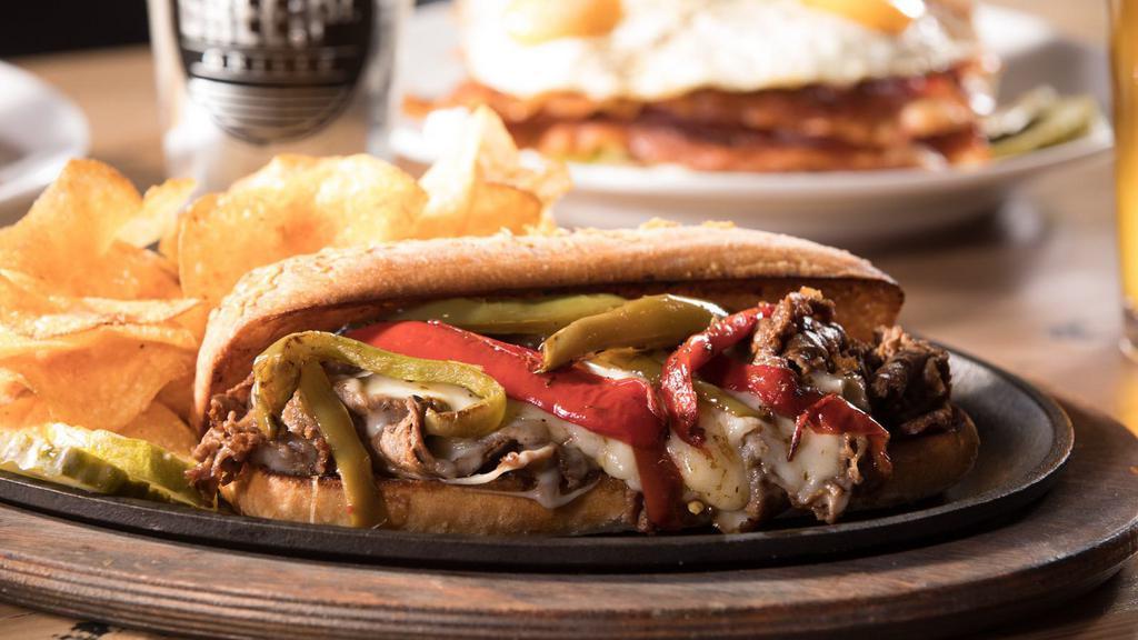 Bacon Philly Cheesesteak · Philly cheesesteak with juicy, chopped steak, your choice of melty cheese, grilled onions, and peppers and crispy bacon on a French roll.