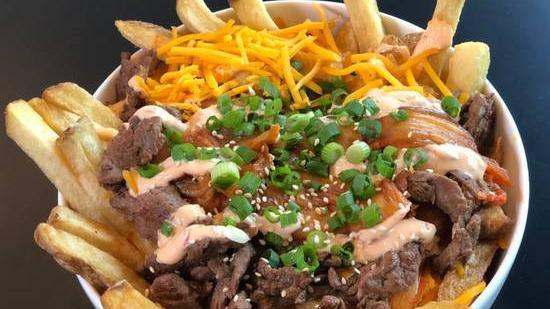 Loaded Korean Fries · Caramelized kimchi, grilled steak, cheddar cheese, samourai sauce, green onions and sesame seeds.