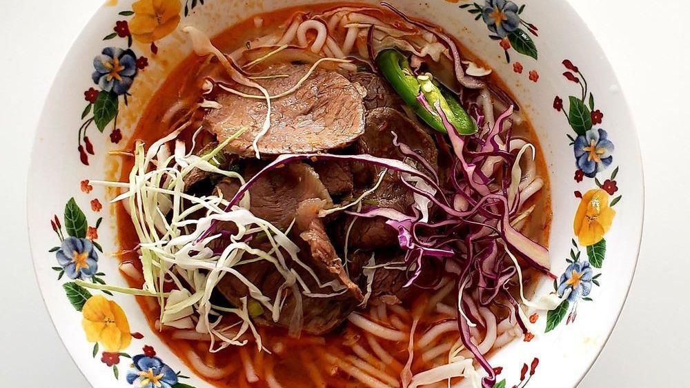 V6.Spicy Noodle Soup · A famous bun hue entrée! Delicious spicy soup with lemongrass flavor, tofu, plump rice noodle, vegetarian “beef”. Served with bean sprouts, basil, lime, and jalapeno.