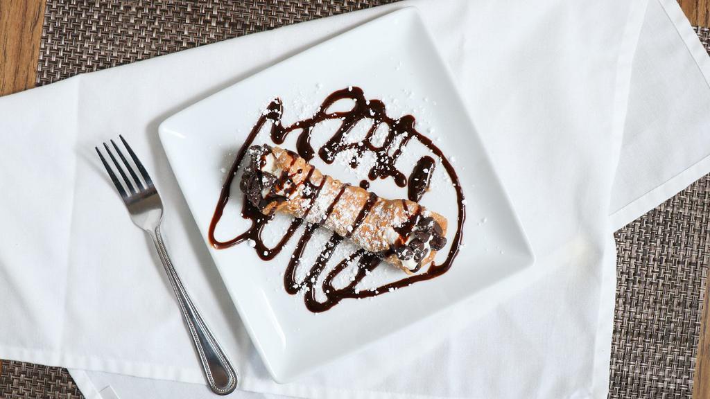Cannoli · Crunchy pastry shell stuffed with sweetened ricotta cheese filling, festooned with chocolate chips and finished with dusting of powdered sugar.