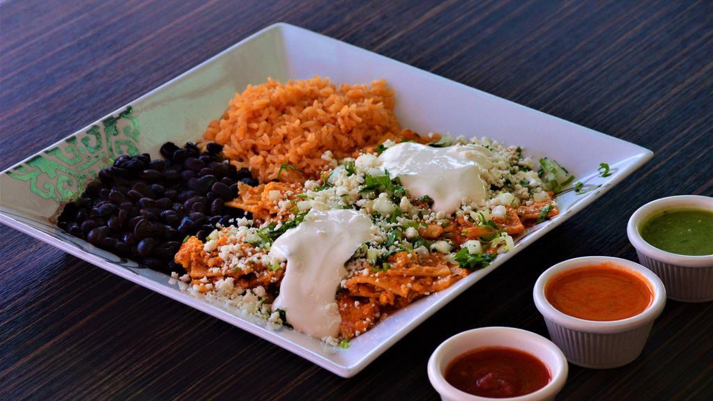 Chilaquiles Con Huevo · Corn tortillas cooked with green or red sauce. Fresh cheese, sour cream, diced onions, and cilantro sprinkled on top. Served with rice, black beans, and 2 eggs.