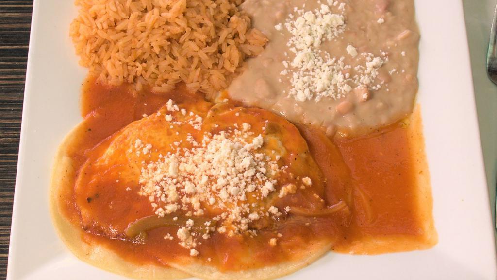 Huevos Rancheros · Two eggs with corn tortillas marinated in red sauce topped with fresh cheese. served with refried and rice.