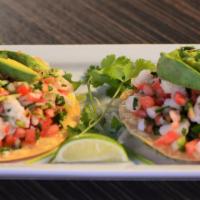 Tostada de Camaron · Lemon marinated fish or shrimp mixed with diced onions, tomatos, cilantro, and avocado.