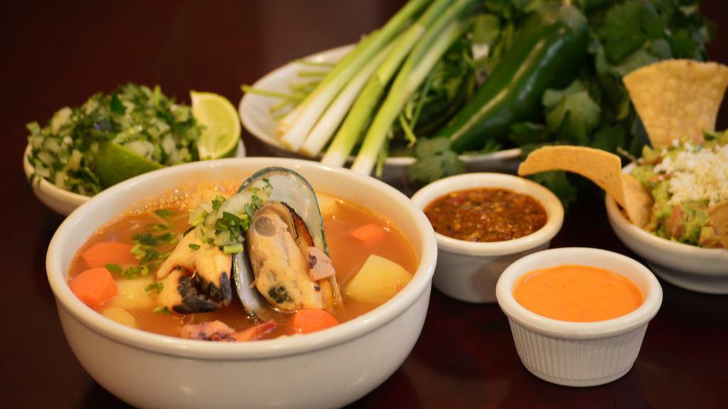 Caldo De 7 Mares · Savoury tomato soup with clams, fish, octupus, shrimp, calamari, crab legs, potatoes, and carrots.