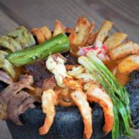 Molcajete · Chicken, beef, chorizo, and shrimp cooked in a
slightly spicy sauce with onions, bell pepper...