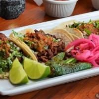 Taco  · Choice of meat, cilantro, onions, and red salsa. ,