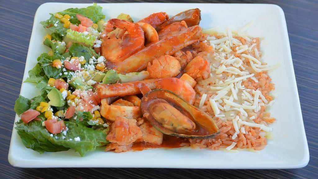 Mariscos Jarochos · Sautéed crab legs, shrimp, muscles, scallops, fish, calamari in a delicious, and spicy salsa diablo. Served with rice topped with melted cheese, diced avocado, pico de gallo, fresh cheese, and tortillas.