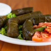 Dolmas · Six pieces of Rolled grape leaves stuffed with rice, flavored with lemon + tzatziki dip