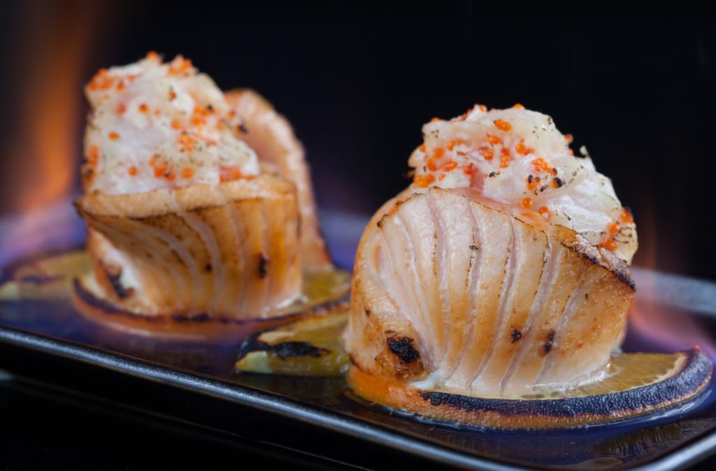 Honeymoon Special  (1.2.) · Chopped spicy scallop, dungeness crab & tobiko seasoned with spicy aioli placed over rice & wrapped with salmon slices (served flambe)