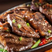 Galbi (9pcs) · Grilled marinated beef short ribs over sautéed mushrooms, bell peppers & onions, topped with...