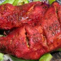 Chicken Tandoori (Half) · Chicken on-the-bone marinated in yogurt and spices  served over onion