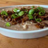 Bacon Refried Beans · Generous Portion of Bacon Refried Beans. Topped with Crispy Bacon Bits and Green Onions. Ser...