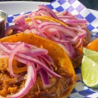 Cochinita Pibil · Braised pork marinated in achiote, bitter orange, and spices. Topped with xnipek salsa (haba...