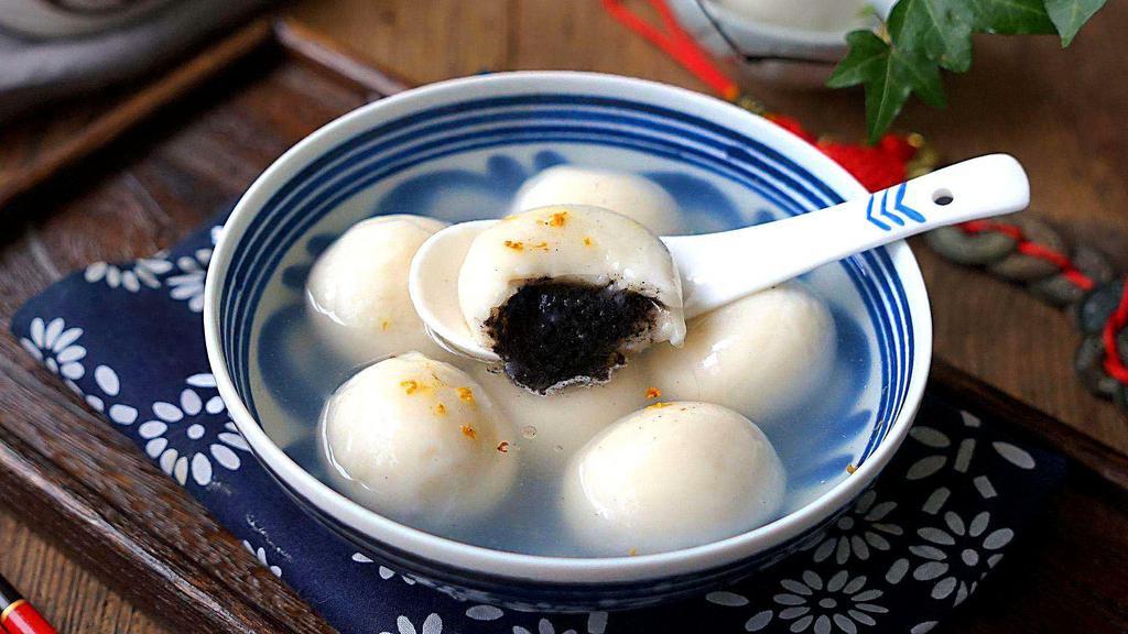 Black Sesame Sweet Rice Balls 宁波芝麻汤圆 · Made with black sesame filling. Served in a sweet rice wine soup, topped with egg drop and osmanthus flower.  正宗宁波‘缸鸭狗’黑芝麻酒酿汤圆
