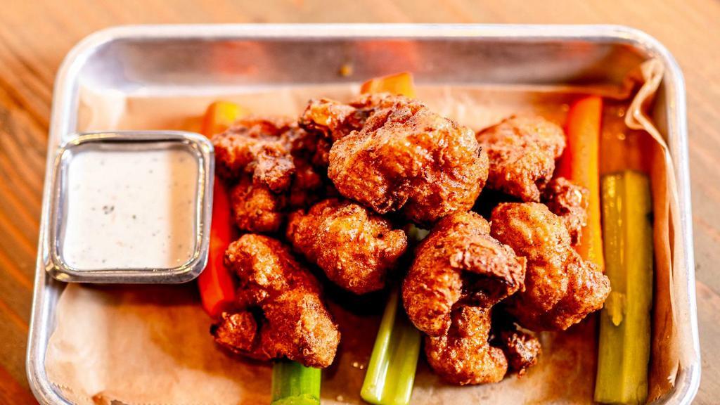 Cauliflower Wings · Cauliflower florets soaked in buttermilk, dredged in seasoned gluten free flour, and fried. Served with carrots, celery, and your choice of wing sauce and dressing.