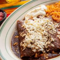 Mole Enchiladas · Two mole enchiladas with chicken. Topped with queso fresco and sour cream. Rice, whole beans.