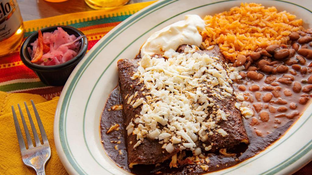 Mole Enchiladas · Two mole enchiladas with chicken. Topped with queso fresco and sour cream. Rice, whole beans.