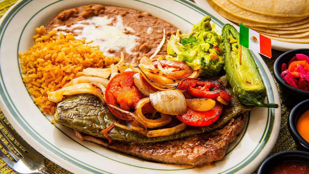 Carne Asada a la Mexicana · Our grilled carne asada accompanied by nopales, onions, tomatoes, guacamole, and roasted jalapeño.