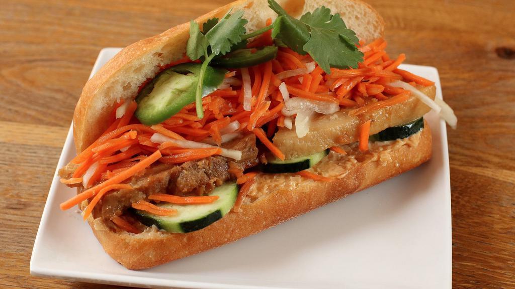 Belly Bun · Braised Kurobuta pork belly, salted radish relish, shaved onion, pickled carrot and daikon, cucumber, jalapenos, and cilantro.