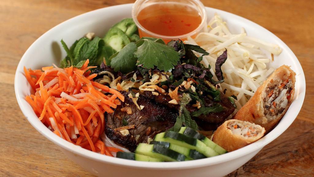 Bun Noodle Bowl · Vermicelli rice noodle, Mamma Tran’s crispy egg roll, lettuce, pickled carrots and daikon, spicy cucumbers, Vietnamese herbs, cilantro, roasted peanuts, and crispy shallots served with a nuoc cham dipping sauce and your choice of grilled pork, chicken, or shrimp.
