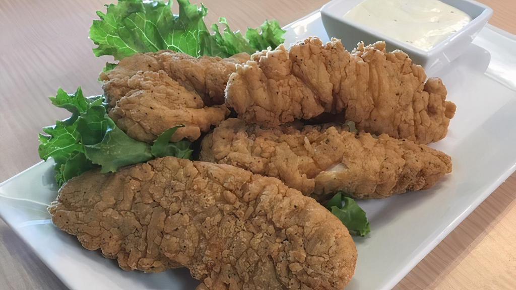 Chicken Tenders · Five chicken tenders cooked to perfection on a bed of lettuce.