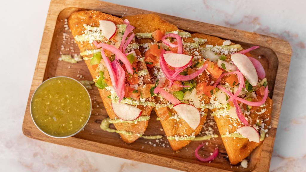 PASTELITOS (3) · Savory Organic Corn Masa Pastries Stuffed With Ground Beef & Potatoes Topped With Fresh Avocado Cream, Cotija Cheese, Pico De Gallo, Pickled Onions & Radishes. Salsa On The Side.