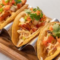 CRISPY FISH TACOS (3) · Wild Cod Marinated In Spices Wrapped In A Crispy Corn Tortilla And Cabbage Slaw. Topped With...