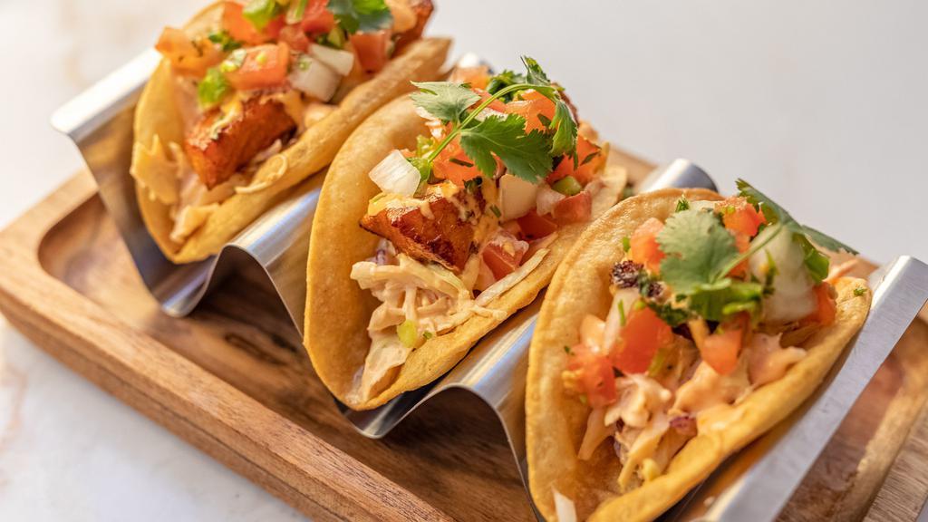 CRISPY FISH TACOS (3) · Wild Cod Marinated In Spices Wrapped In A Crispy Corn Tortilla And Cabbage Slaw. Topped With Fresh Pico De Gallo And Our Secret Pink Sauce. Spicy Salsa On The Side.