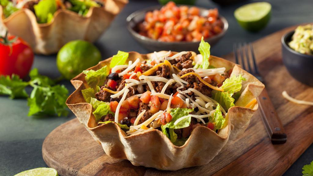 Taco Salad · Fresh romaine tossed with rice, beans, fresh salsa, guacamole, cheeses and sour cream with a crisp tortilla shell.