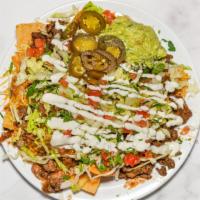 Nachos · The nachos consist of our chips made from our corn tortillas and topped with onions, tomato,...