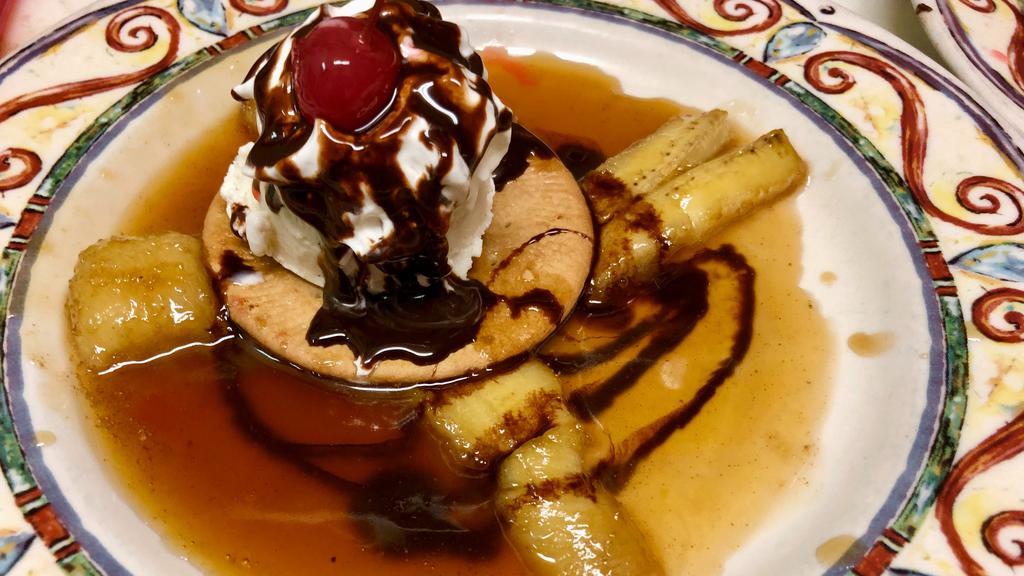 Bananas Borrachas · Fried bananas surrounding a scoop of vanilla bean ice cream, sitting on a Mexican cookie covered with sweet almond tequila sauce.
