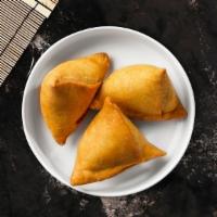 Lamb Samosa · Two crispy puffs filled with ground lamb, onions and herbs fried in a crispy wheat layer.