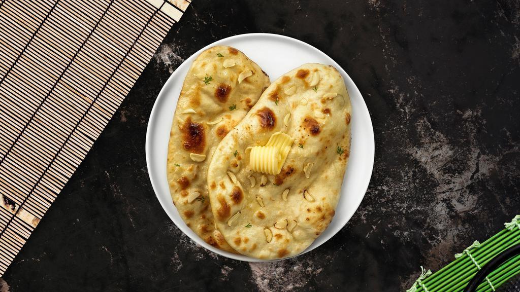 Garlic Naan · Freshly baked bread in a clay oven garnished with garlic and butter