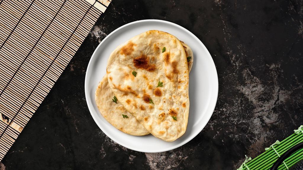 Sweet Naan · Freshly baked bread garnished with sugar, coconut, and raisins,
