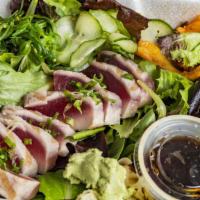 Seared Ahi · Seared Tuna on top of spring mix. Served with Ponzu sauce, spicy squid, cucumber and seaweed...