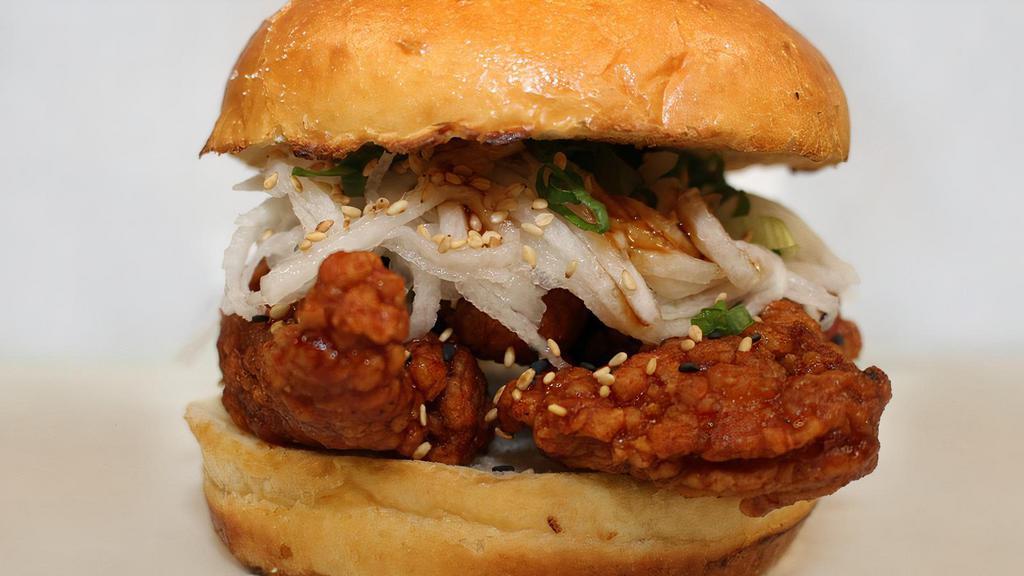 Cluckbanger · Chicken sandwich infused with awesome Korean flavors! Sweet and tangy with a mild kick, topped with a daikon radish salad and sesame seeds on a brioche bun.
