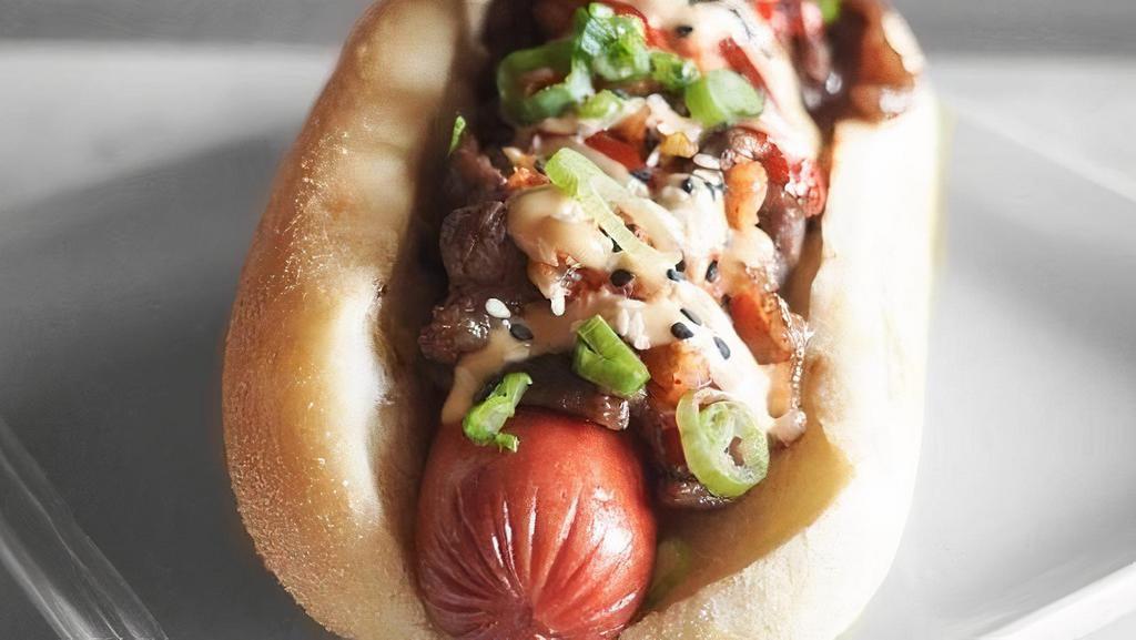 Bulgogi Dog · 100% Angus beef hot dog, topped with kimchi relish, sliced marinated Korean beef, teriyaki mayo, Korean chili sauce, green onions, sprinkled with black and white sesame seeds on a brioche bun.