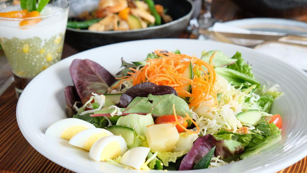 House Salad · Roman lettuces, iceberg lettuces, mixed spring salad, sliced cabbages, carrots, tomatoes, pineapple and boiled eggs served with peanut dressing.