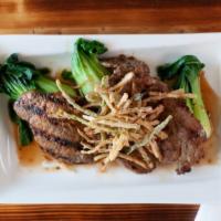 Moo Yang · Grilled coriander crusted center cut pork served with bok choy and crispy leeks.