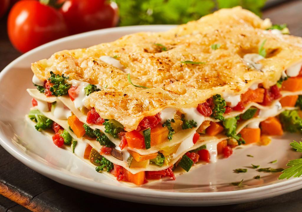 Vegetarian Lasagna · Made with roasted vegetables, zucchini, carrots, onions, and spinach in a marinara base sauce.