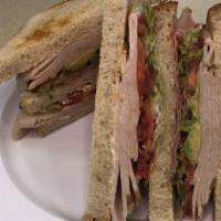 Gone Clubbin' · Triple-decker sandwich on toasted sliced sourdough bread with turkey, bacon, avocado, lettuc...
